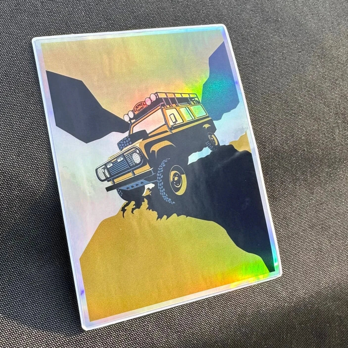 Holographic sticker of a Camel Trophy Landrover traversing a hillside